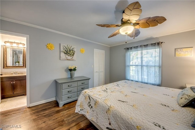 bedroom with ornamental molding, baseboards, and wood finished floors