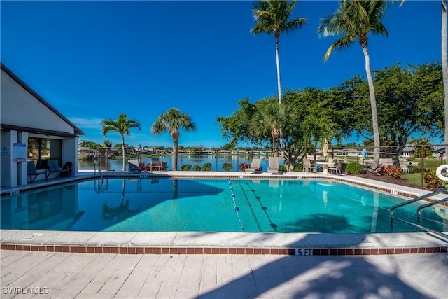 pool featuring a water view, fence, and a patio