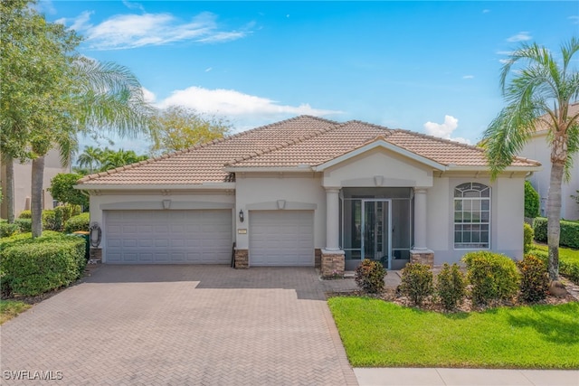 2042 Mandarin Ln, Naples, FL 34120 - mediterranean / spanish home featuring decorative driveway, a garage, and stucco siding
