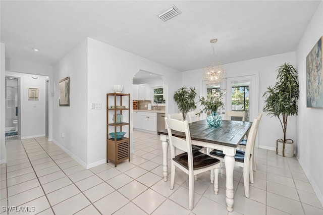 dining room featuring visible vents, arched walkways, a notable chandelier, and light tile patterned floors
