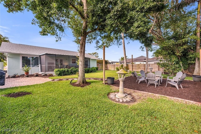 view of yard with a sunroom, a patio, and a fenced backyard
