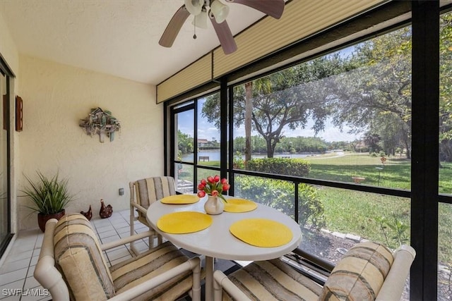 sunroom / solarium with a water view and ceiling fan