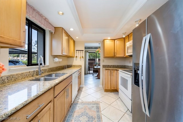 kitchen featuring light tile patterned flooring, white appliances, a raised ceiling, light stone counters, and a sink