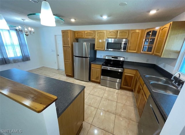 25 Estate Dr, North Fort Myers, FL 33917 - kitchen featuring glass insert cabinets, a sink, appliances with stainless steel finishes, dark countertops, and a chandelier