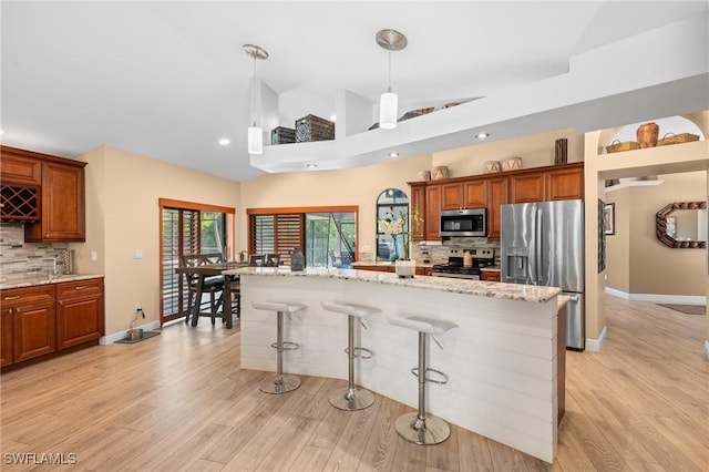 kitchen featuring backsplash, appliances with stainless steel finishes, and light stone countertops