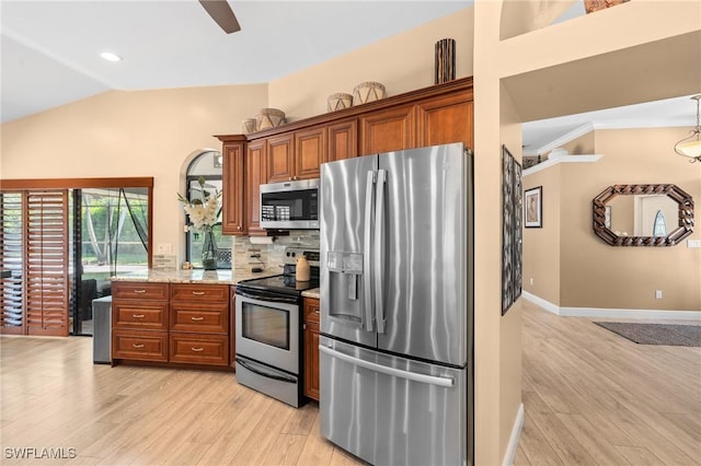 kitchen featuring light wood-style floors, tasteful backsplash, vaulted ceiling, stainless steel appliances, and brown cabinets