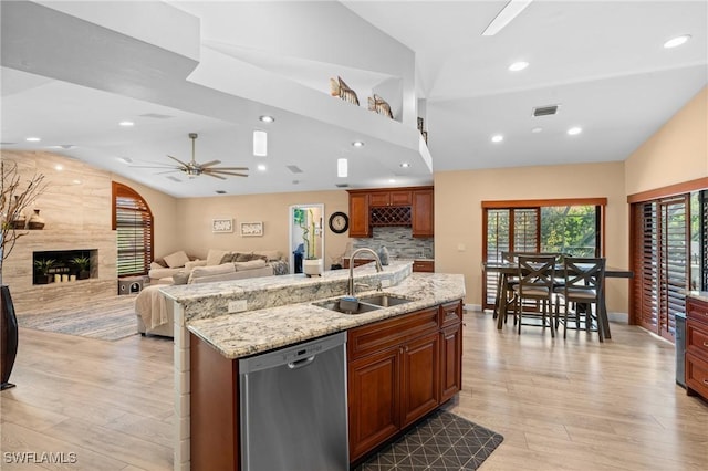 kitchen featuring ceiling fan, stainless steel dishwasher, light wood-type flooring, visible vents, and a sink