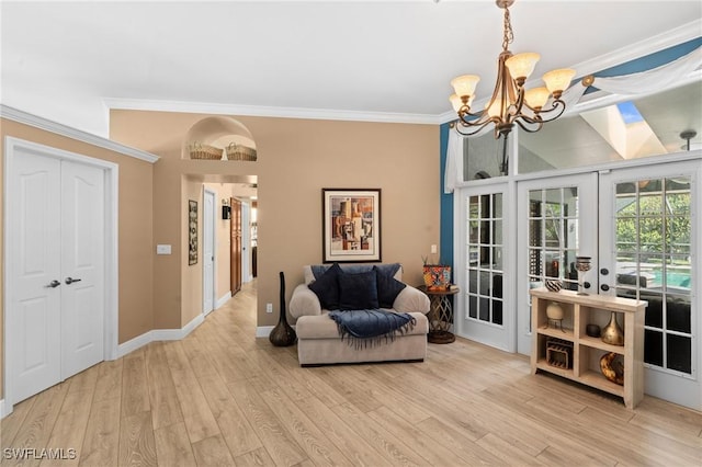living area with a notable chandelier, baseboards, french doors, crown molding, and wood finished floors