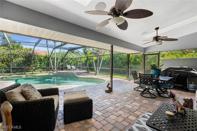 outdoor pool with glass enclosure, a patio, and a ceiling fan