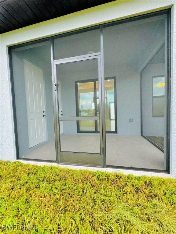 property entrance with stucco siding