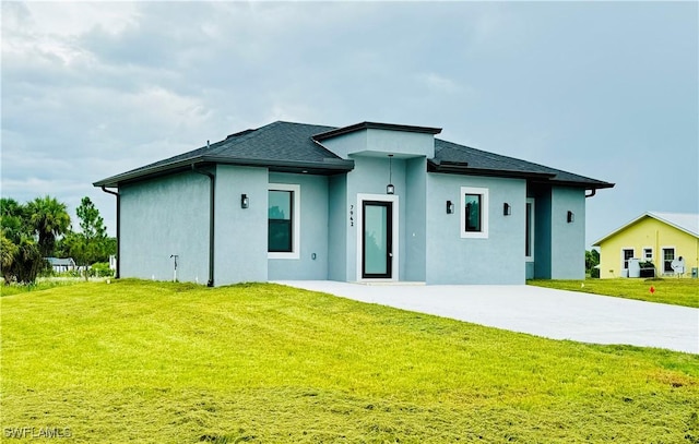 view of front facade with driveway, stucco siding, and a front lawn