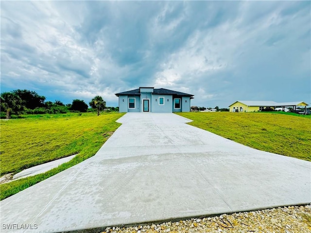 view of front of home with driveway and a front lawn
