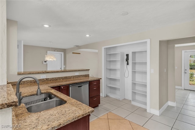 kitchen with a sink, light stone counters, light tile patterned flooring, and dishwasher
