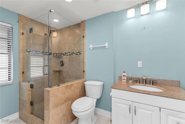 bathroom with toilet, a stall shower, baseboards, and vanity