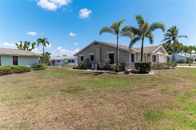 exterior space featuring an attached garage, stucco siding, central AC unit, and a lawn