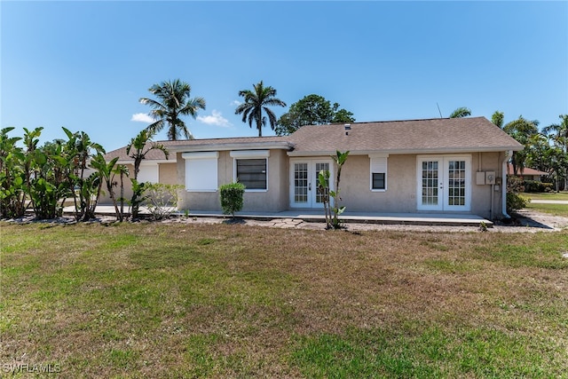 single story home with a front yard, french doors, and stucco siding