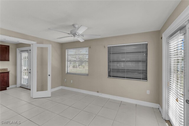 unfurnished bedroom with light tile patterned floors, baseboards, and ceiling fan