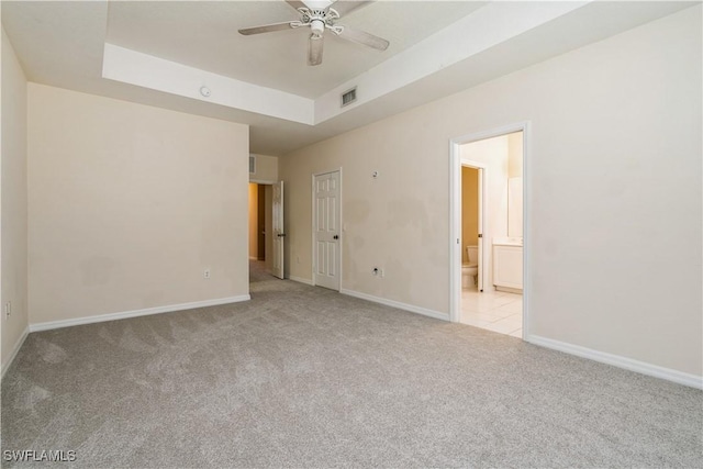 spare room featuring carpet floors, ceiling fan, visible vents, and baseboards