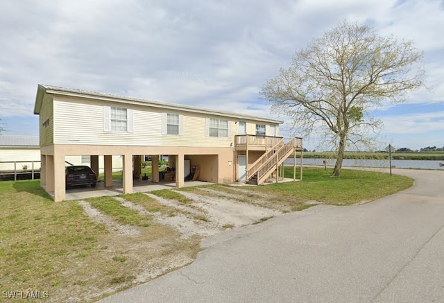 901 Thatcher Blvd, Moore Haven, FL 33471 - rear view of property with dirt driveway, a carport, stairway, a yard, and a deck with water view