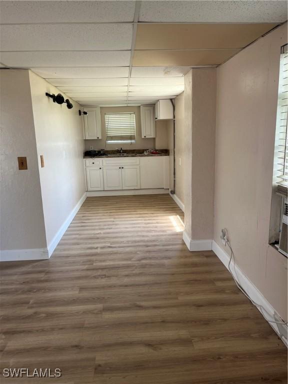 901 Thatcher Blvd, Moore Haven, FL 33471 - kitchen with dark countertops, baseboards, a drop ceiling, light wood finished floors, and white cabinetry