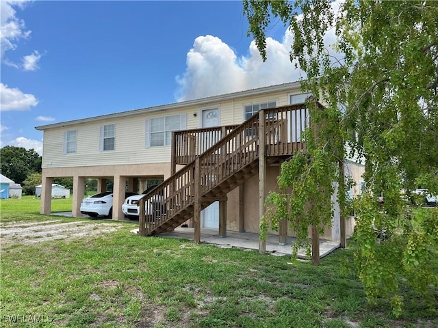 901 Thatcher Blvd, Moore Haven, FL 33471 - rear view of house with stairs, a carport, a deck, and a yard