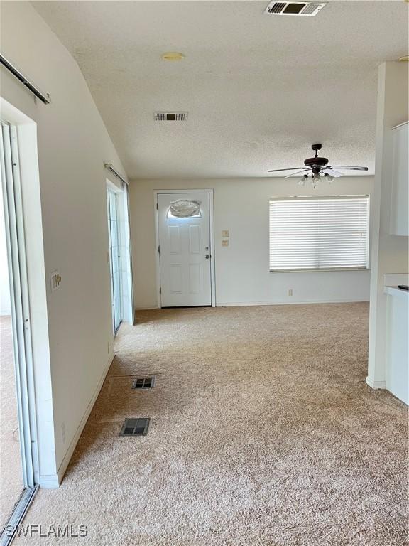 901 Thatcher Blvd, Moore Haven, FL 33471 - entrance foyer featuring carpet, ceiling fan, plenty of natural light, and a textured ceiling