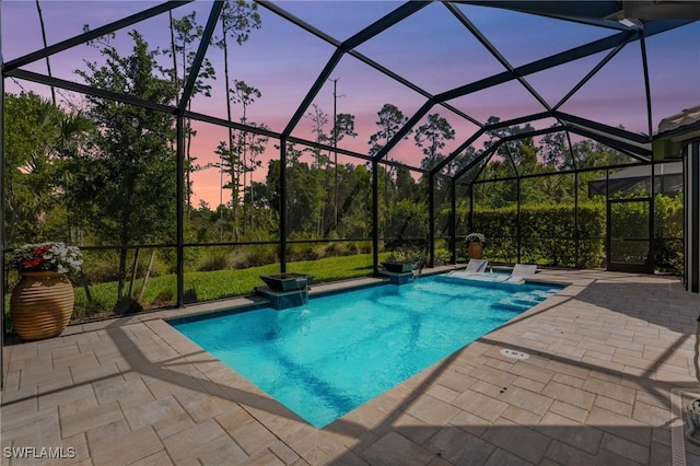 pool at dusk featuring a lanai, a patio, and an outdoor pool
