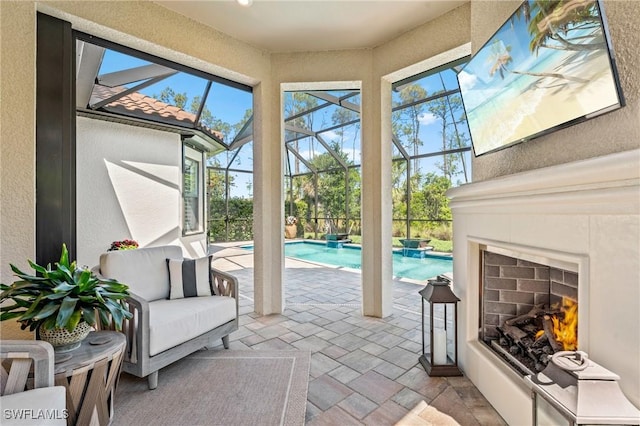 exterior space featuring a textured wall, exterior fireplace, stone tile floors, and a sunroom