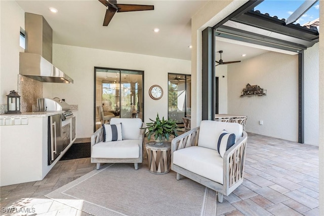 sitting room featuring a ceiling fan, stone finish floor, and recessed lighting