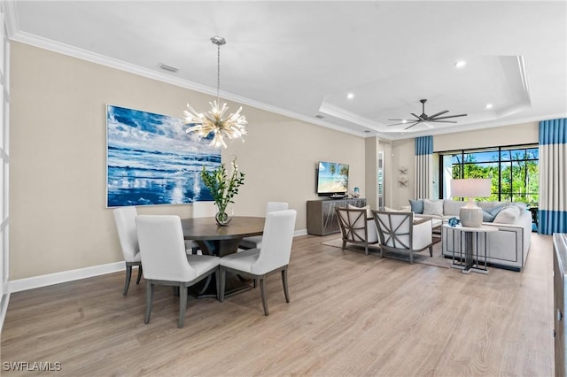 dining space with baseboards, ornamental molding, recessed lighting, light wood-style floors, and a tray ceiling