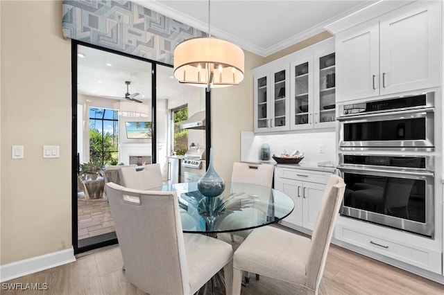 dining room with light wood-style flooring, crown molding, ceiling fan, and baseboards