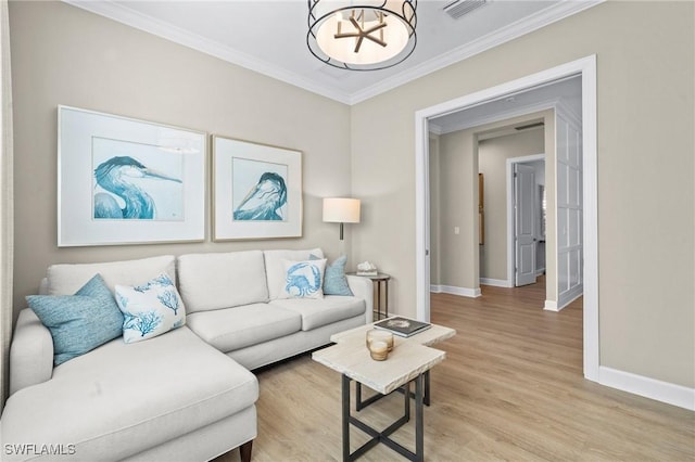 living area featuring visible vents, baseboards, ornamental molding, a chandelier, and light wood-style flooring