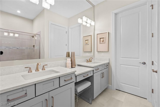 bathroom featuring tile patterned floors, tiled shower, double vanity, and a sink