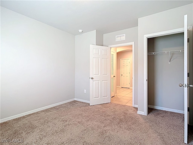 24692 Rio Villa Lakes Cir, Punta Gorda, FL 33950 - unfurnished bedroom featuring visible vents, baseboards, a closet, arched walkways, and carpet
