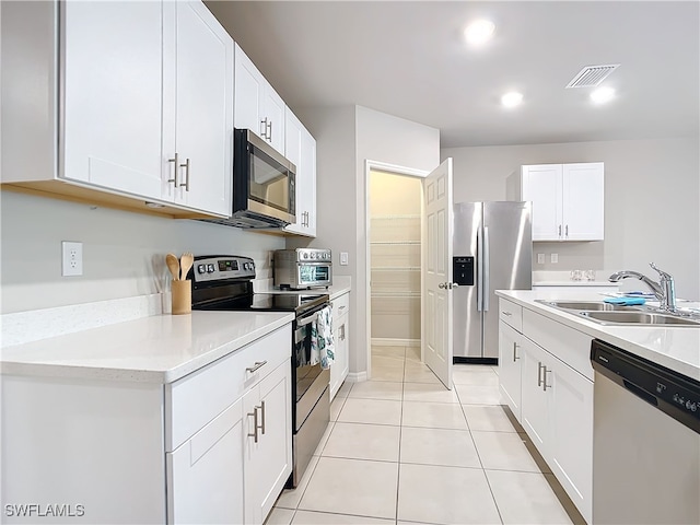 24692 Rio Villa Lakes Cir, Punta Gorda, FL 33950 - kitchen featuring light tile patterned floors, white cabinets, visible vents, appliances with stainless steel finishes, and a sink