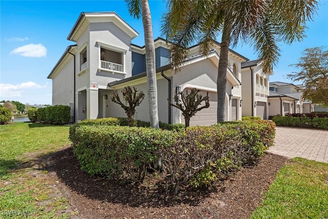 3536 Cherry Blossom Ct Unit 201, Estero, FL 33928 - view of property exterior with decorative driveway, stucco siding, a balcony, and a garage