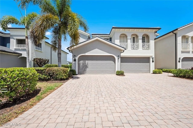 3536 Cherry Blossom Ct Unit 201, Estero, FL 33928 - view of front of home with decorative driveway, stucco siding, a balcony, and an attached garage