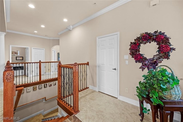 hall with crown molding, baseboards, an upstairs landing, and arched walkways
