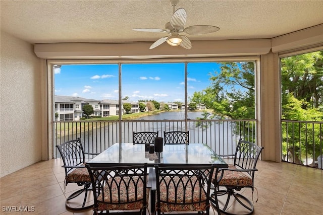 sunroom featuring a water view