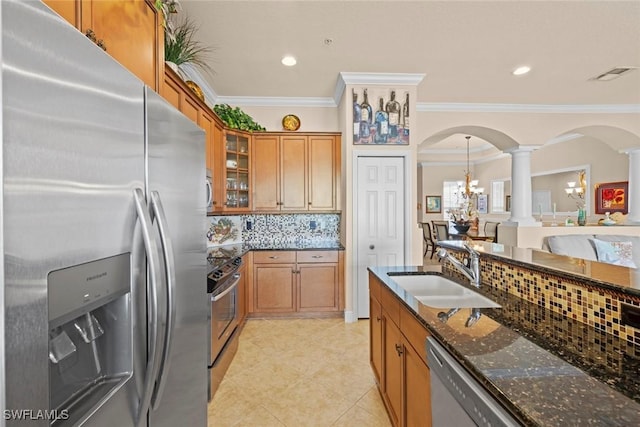 3536 Cherry Blossom Ct Unit 201, Estero, FL 33928 - kitchen with stainless steel appliances, decorative columns, arched walkways, brown cabinets, and dark stone countertops