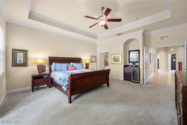 3536 Cherry Blossom Ct Unit 201, Estero, FL 33928 - bedroom with a raised ceiling, arched walkways, ornamental molding, light carpet, and wine cooler