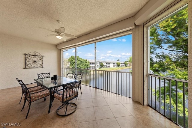 3536 Cherry Blossom Ct Unit 201, Estero, FL 33928 - dining space featuring a water view, ceiling fan, a textured wall, light tile patterned floors, and a textured ceiling
