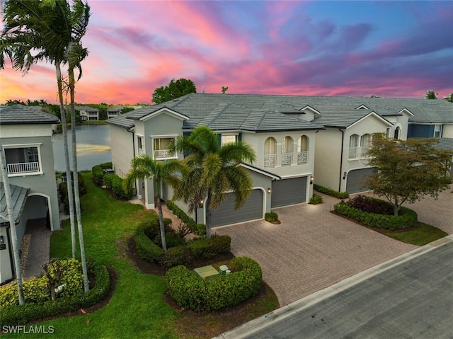 3536 Cherry Blossom Ct Unit 201, Estero, FL 33928 - view of front of house with a garage, driveway, stucco siding, and a balcony