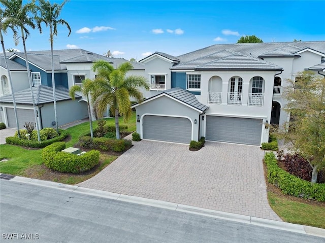 3536 Cherry Blossom Ct Unit 201, Estero, FL 33928 - view of front of home with a balcony, driveway, stucco siding, and a garage