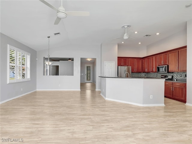 17274 Asmara Ct, Punta Gorda, FL 33955 - kitchen with ceiling fan, appliances with stainless steel finishes, open floor plan, reddish brown cabinets, and high vaulted ceiling