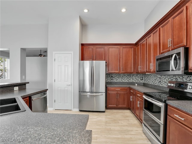 17274 Asmara Ct, Punta Gorda, FL 33955 - kitchen featuring appliances with stainless steel finishes, light wood finished floors, decorative backsplash, a sink, and ceiling fan