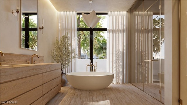 936 5th Ave S Unit 202, Naples, FL 34102 - bathroom with a soaking tub, expansive windows, vanity, wood finished floors, and french doors