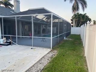 8860 Banyan Cove Cir S Unit 0, Fort Myers, FL 33919 - view of side of property featuring a fenced backyard, glass enclosure, and a patio area