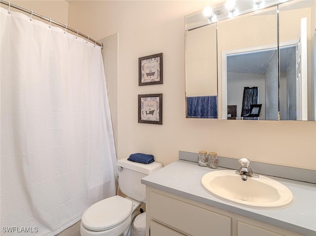 bathroom with toilet, vanity, and a shower with curtain
