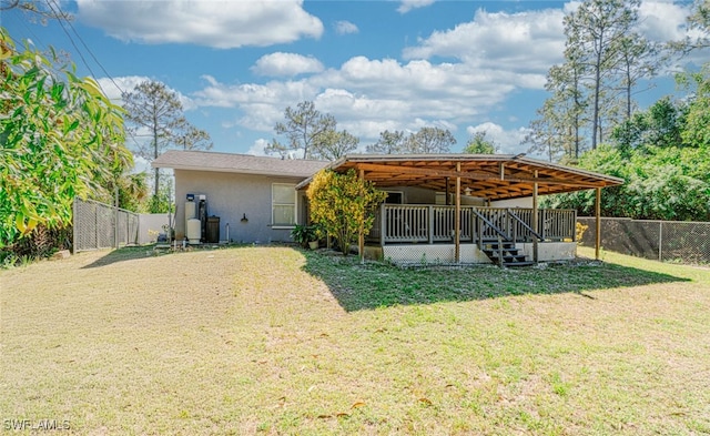back of house with a fenced backyard, a yard, and stucco siding